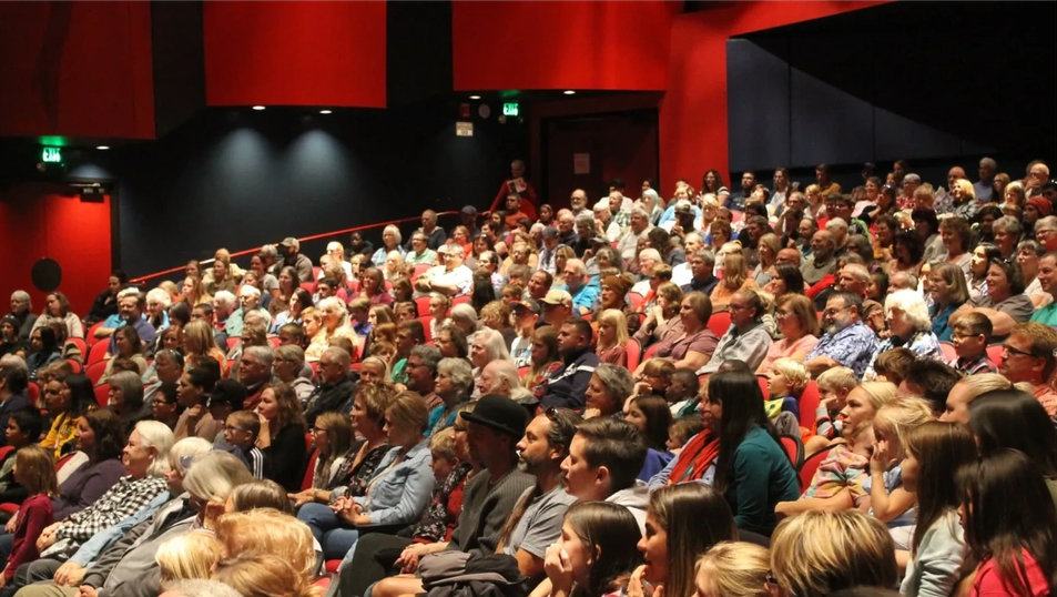 A photo of audience members seated at the PAC.